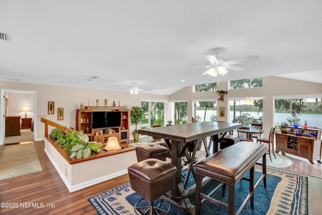 dining space featuring ceiling fan, a textured ceiling, and dark hardwood / wood-style flooring