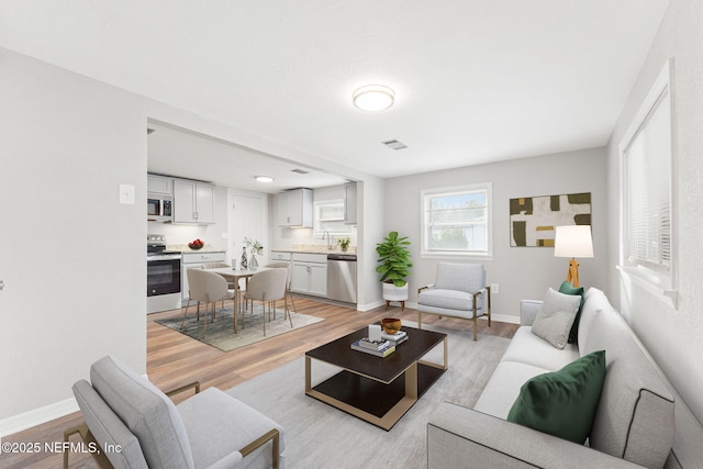 living room featuring light wood-type flooring and sink