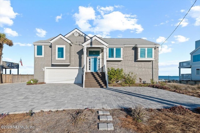 view of front of property featuring a garage and a water view