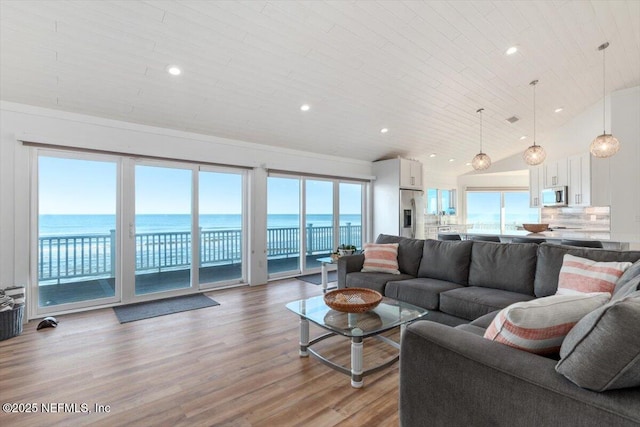 living room featuring wood ceiling, light hardwood / wood-style floors, a wealth of natural light, and a water view