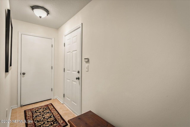 entryway featuring a textured ceiling and light tile patterned flooring