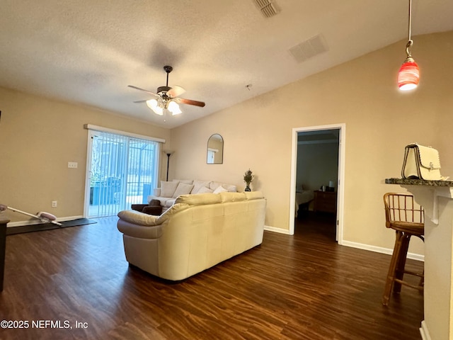 living room featuring a textured ceiling, dark wood-type flooring, ceiling fan, and vaulted ceiling