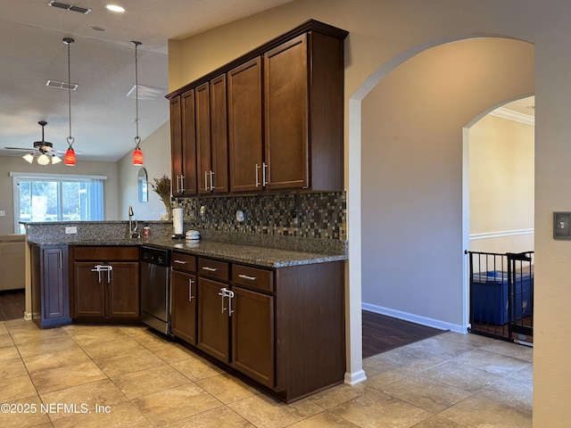 kitchen featuring hanging light fixtures, backsplash, stainless steel dishwasher, kitchen peninsula, and dark stone counters