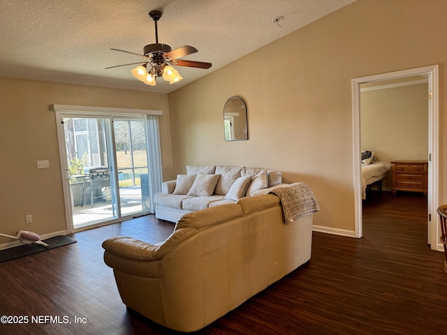 living room featuring dark hardwood / wood-style flooring, ceiling fan, vaulted ceiling, and a textured ceiling