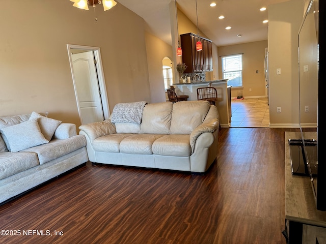 living room featuring high vaulted ceiling, dark wood-type flooring, and ceiling fan