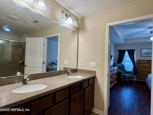 bathroom featuring walk in shower, a textured ceiling, vanity, ceiling fan, and hardwood / wood-style floors