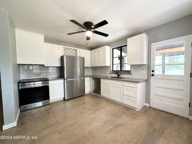 kitchen with appliances with stainless steel finishes, white cabinetry, decorative backsplash, sink, and ceiling fan