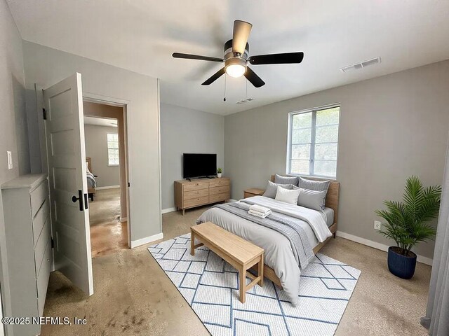 bedroom with baseboards, visible vents, and a ceiling fan