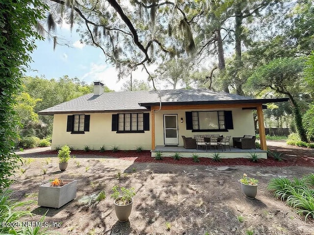 ranch-style house with a patio, a chimney, and roof with shingles