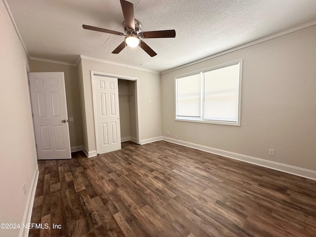 unfurnished bedroom featuring ceiling fan, dark wood-type flooring, a textured ceiling, ornamental molding, and a closet