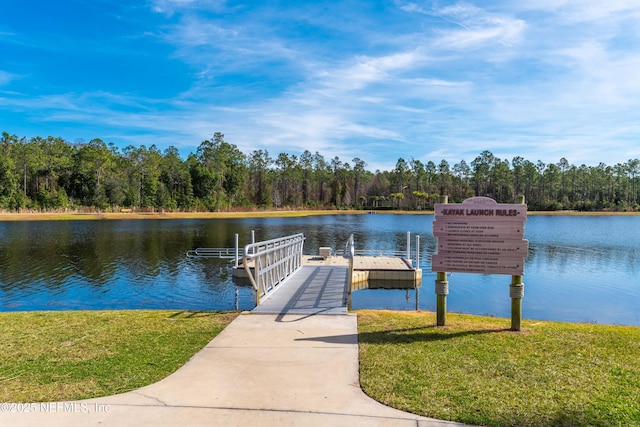 view of dock featuring a water view and a yard