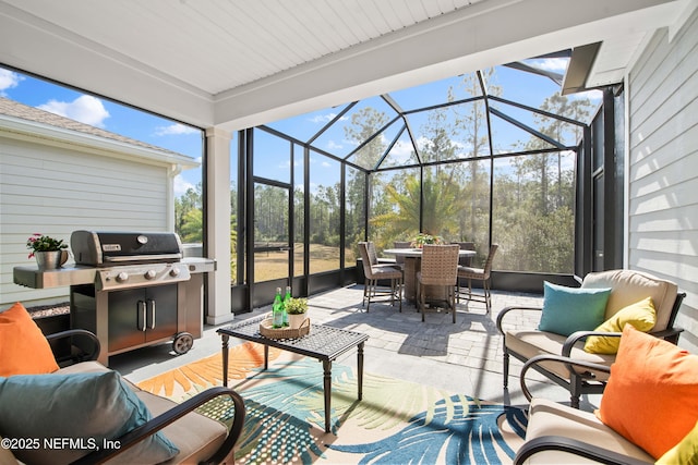 view of patio / terrace with area for grilling, an outdoor living space, and a lanai