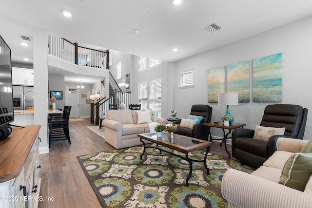 living room featuring a notable chandelier and light wood-type flooring