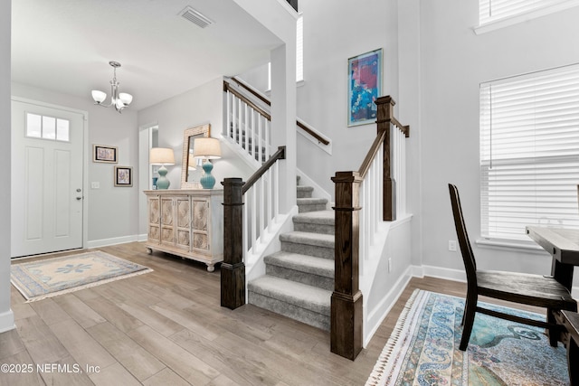 foyer with an inviting chandelier and light wood-type flooring