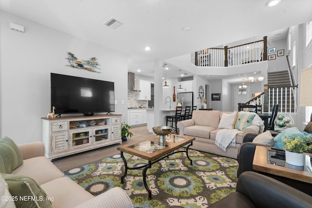 living room with sink, a chandelier, and hardwood / wood-style floors