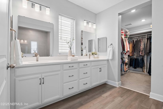 bathroom with vanity, hardwood / wood-style flooring, and a healthy amount of sunlight