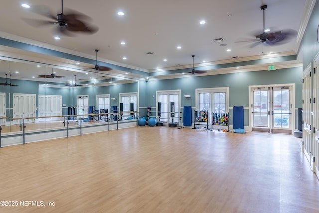 workout area featuring crown molding, french doors, and light wood-type flooring