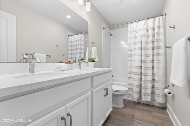 bathroom with wood finished floors, shower / tub combo with curtain, double vanity, and a sink