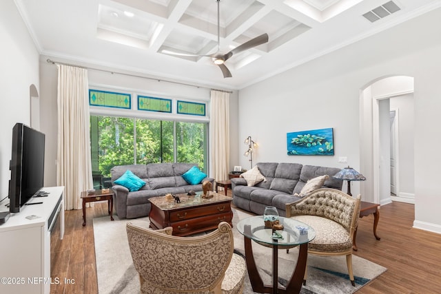 living room featuring arched walkways, wood finished floors, and visible vents