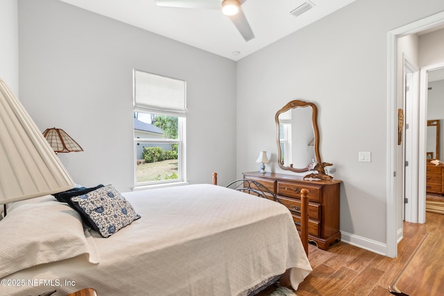 bedroom featuring light wood-type flooring, visible vents, ceiling fan, and baseboards