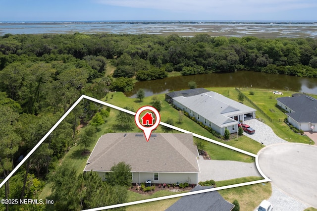 birds eye view of property featuring a forest view and a water view