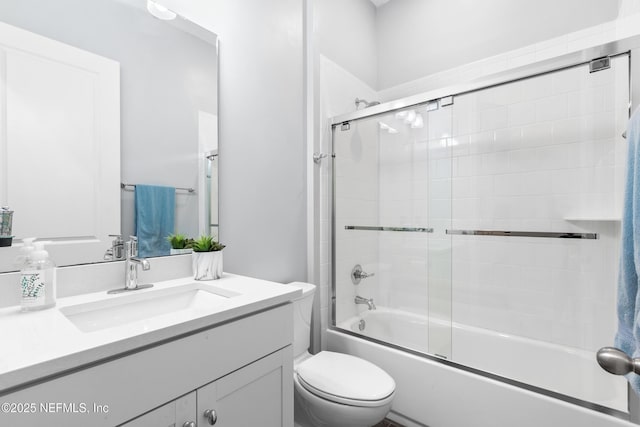 full bathroom with shower / bath combination with glass door, vanity, and toilet