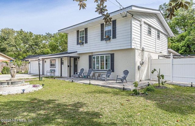 view of front of property featuring a garage, a patio area, and a front lawn