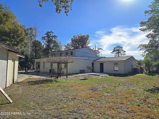 back of house with a lawn and a patio area