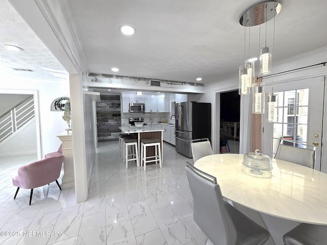 dining space with ornamental molding and sink