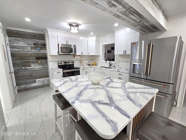 kitchen featuring stainless steel appliances, a kitchen island, light stone countertops, and a kitchen breakfast bar