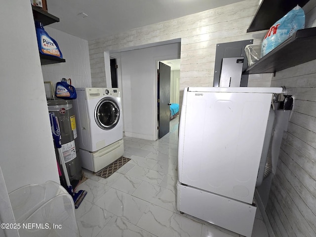 clothes washing area with wooden walls, washing machine and dryer, and water heater