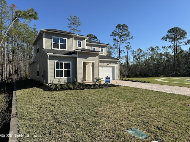 prairie-style home with decorative driveway and a front lawn