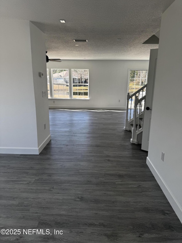 hall with dark hardwood / wood-style flooring and a textured ceiling