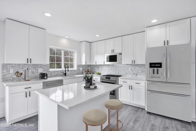 kitchen with refrigerator with ice dispenser, gas range, sink, and white cabinets