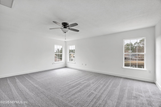 carpeted spare room featuring ceiling fan and a textured ceiling