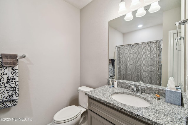 bathroom with curtained shower, toilet, and vanity