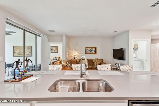 kitchen featuring washer / dryer, dishwasher, and sink