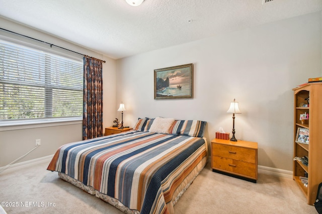 bedroom with light carpet and a textured ceiling