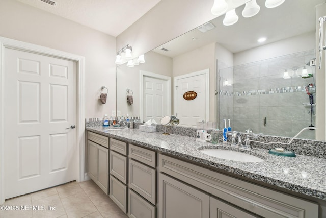 bathroom featuring a shower with door, tile patterned floors, and vanity