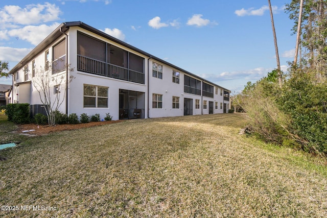 rear view of property with a lawn and a sunroom