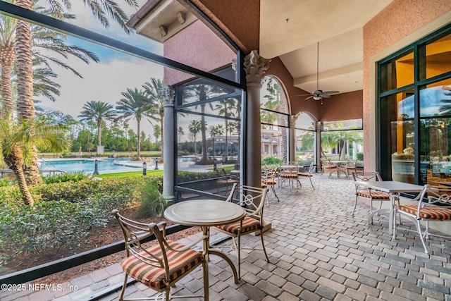 sunroom with ceiling fan and vaulted ceiling