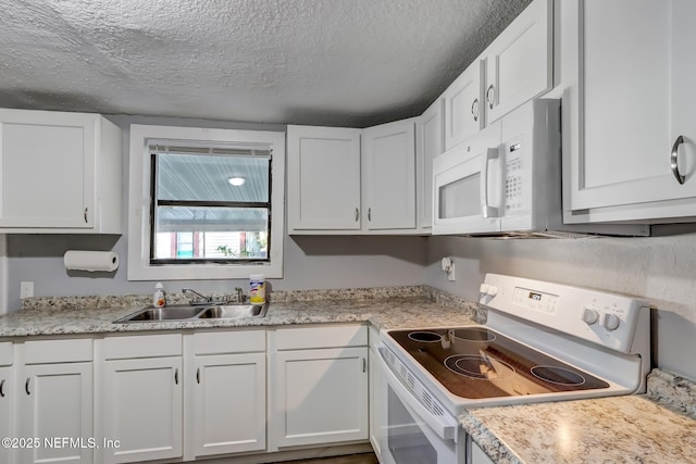 kitchen with a textured ceiling, white cabinetry, sink, and white appliances