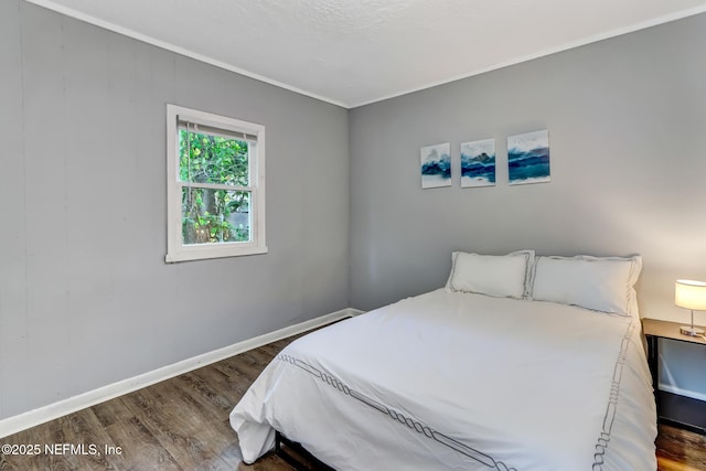 bedroom with dark wood-type flooring and crown molding