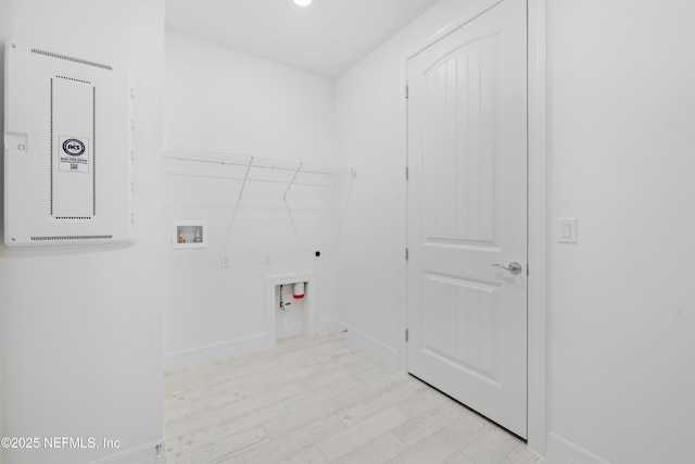 clothes washing area featuring electric dryer hookup, hookup for a washing machine, and light wood-type flooring