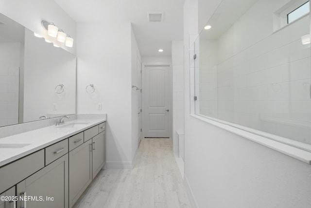 bathroom featuring vanity, tiled shower, and hardwood / wood-style floors