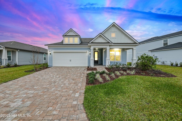 view of front of house featuring a garage and a lawn