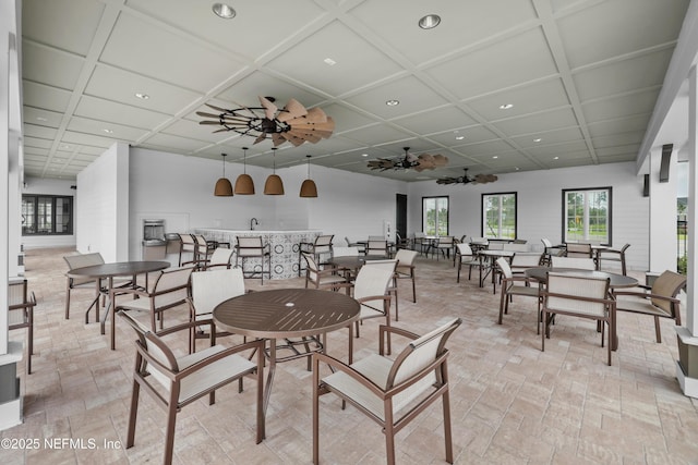 dining space featuring ceiling fan and coffered ceiling