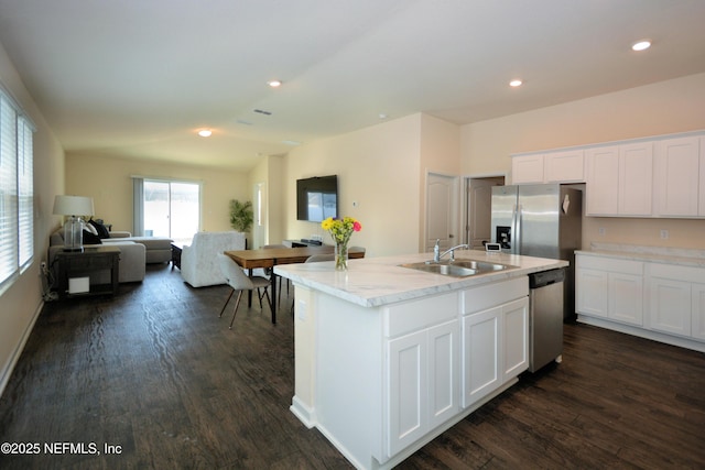 kitchen with dark wood-type flooring, sink, a center island with sink, stainless steel appliances, and white cabinets