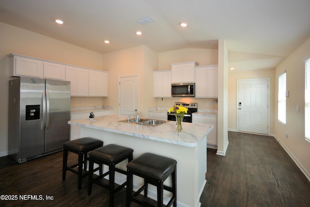 kitchen with white cabinetry, sink, stainless steel appliances, and a center island with sink