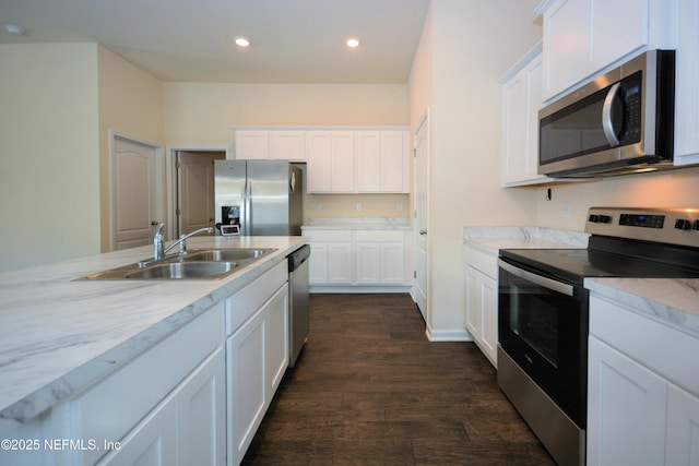 kitchen with appliances with stainless steel finishes, sink, white cabinets, and dark hardwood / wood-style flooring